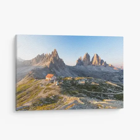 Canvas print sunlit mountain refuge at dawn • Wallissimo®