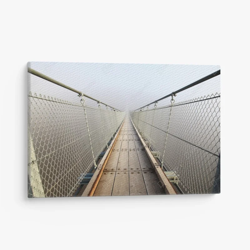 Canvas print misty suspension bridge leading into fog