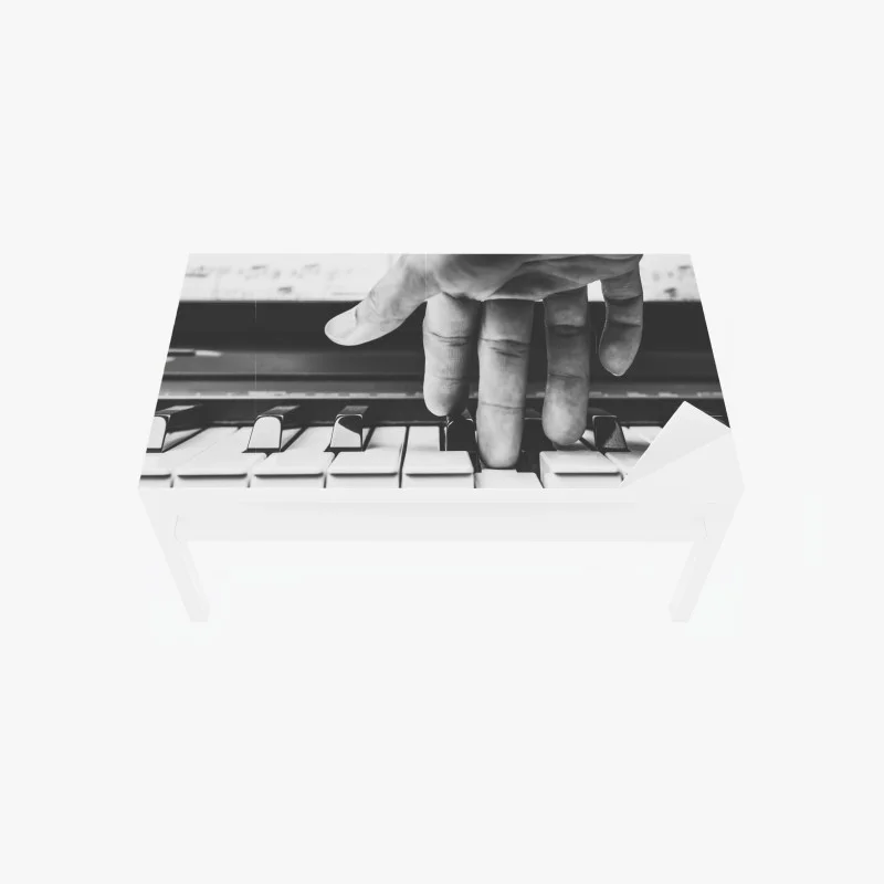 Table & desk veneer hand on piano keys in grayscale