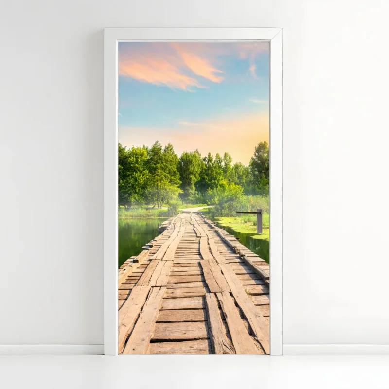 Door sticker sunlit wooden bridge over tranquil lake