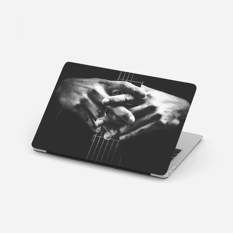 Laptop sticker intertwined hands on guitar strings