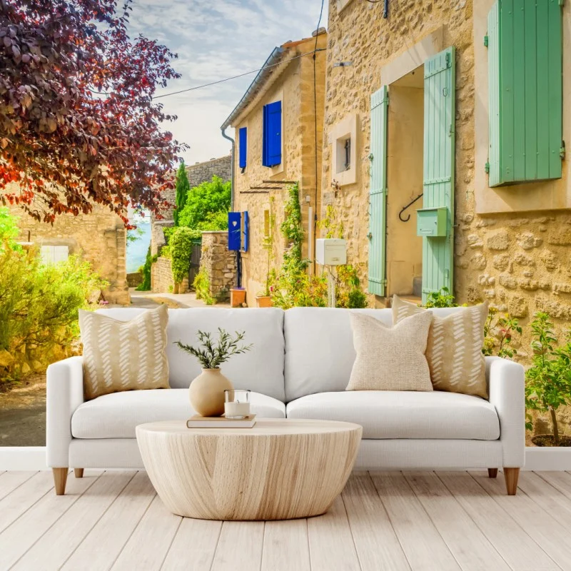 Wall mural sunlit stone village street with colorful shutters