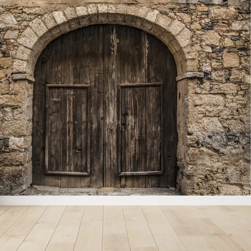 Wall mural rustic wooden door with stone arch