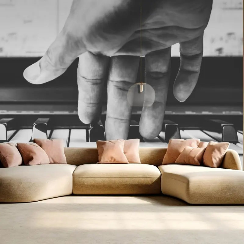 Wall mural hand on piano keys in grayscale