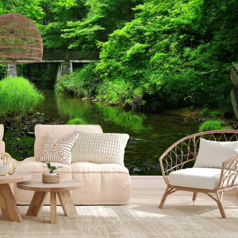 Wall mural lush green forest stream with stone bridge