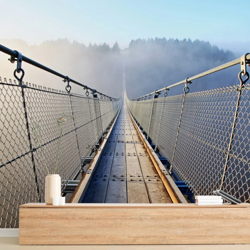 Wall mural foggy suspension bridge leading into the woods