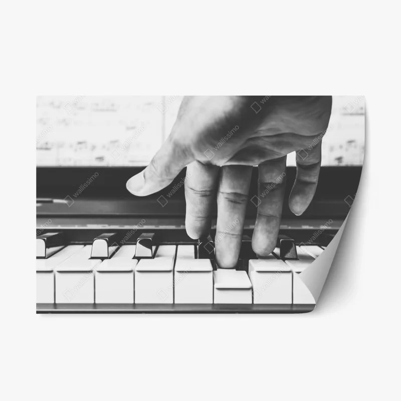 Repositionable sticker hand on piano keys in grayscale