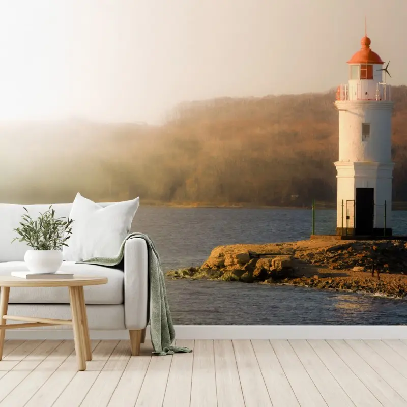 Wall mural sunlit lighthouse on misty shore