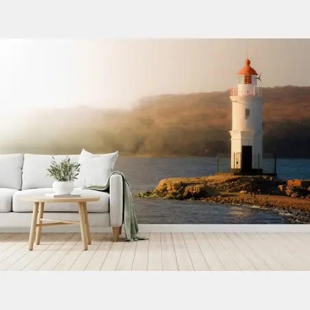 Wall mural sunlit lighthouse on misty shore • Wallissimo®