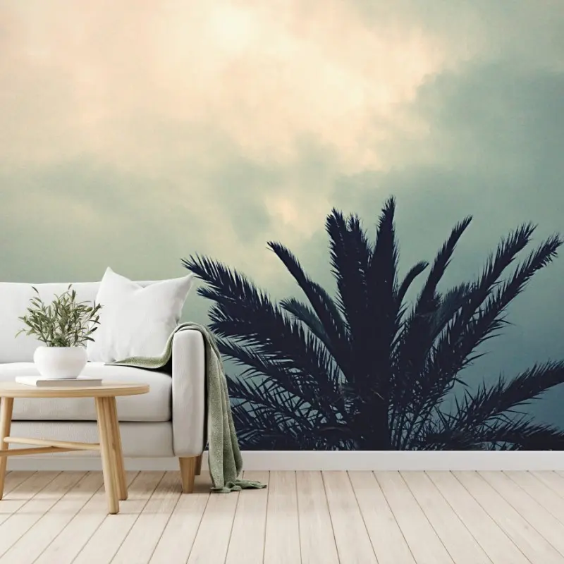 Wall mural moody palm silhouette against a cloudy sky