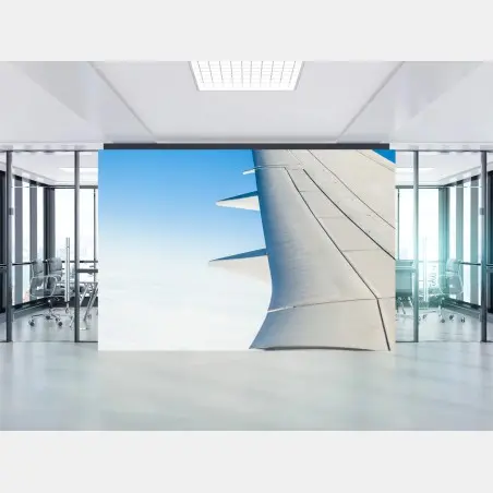 Wall mural wing above clouds in clear blue sky • Wallissimo®