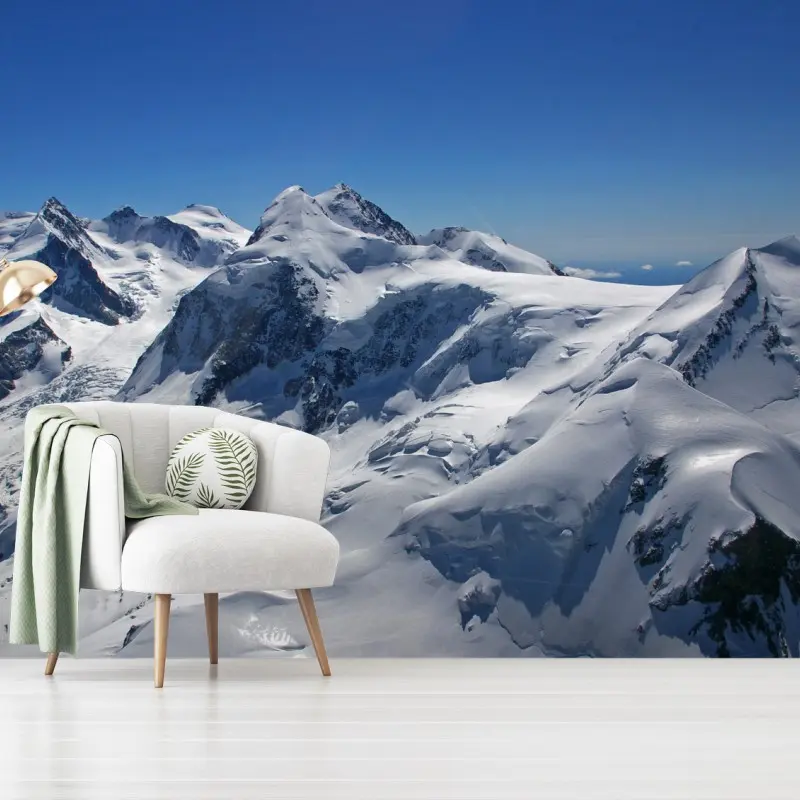 Wall mural snow-covered alpine peaks under clear blue sky