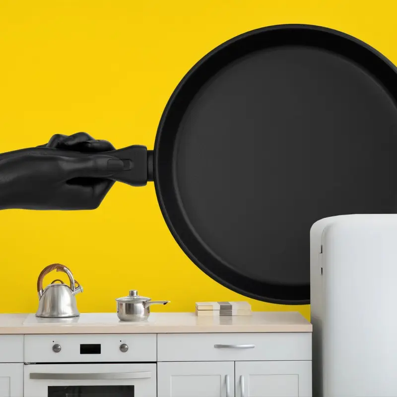 Wall mural black pan on vibrant yellow background
