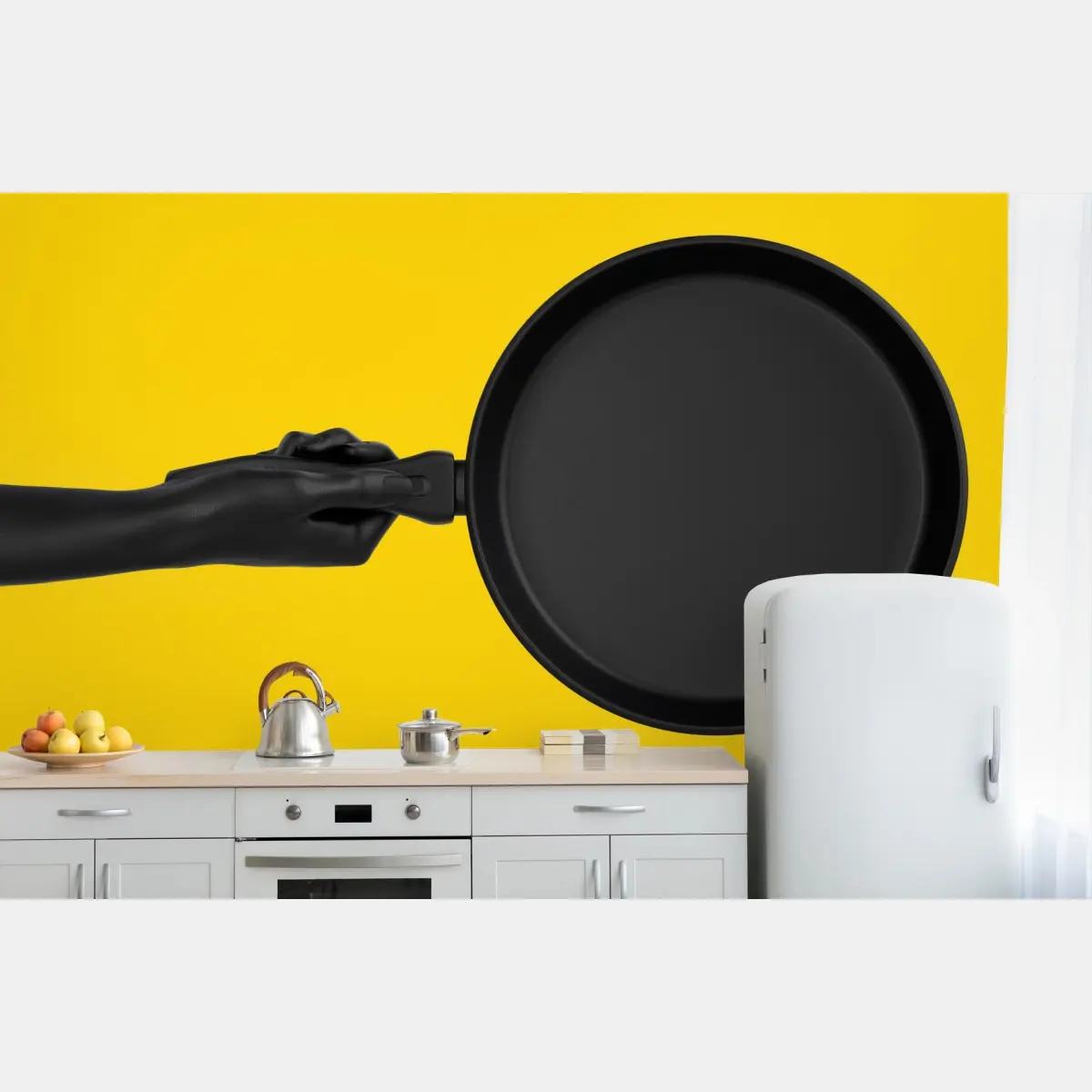 Wall mural black pan on vibrant yellow background • Wallissimo®