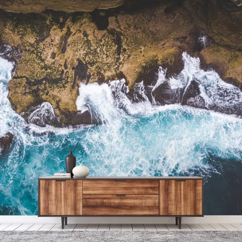 Wall mural turquoise surf over rocky coastline